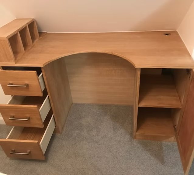 Brown wooden desk with three drawers and shelves for storage.