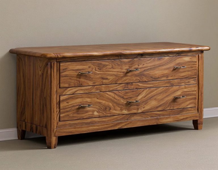 Wooden chest of drawers with three front drawers and a natural finish.