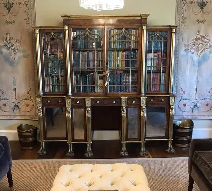 Elegant antique cabinet with glass doors, ornate detailing, and mirrored accents.